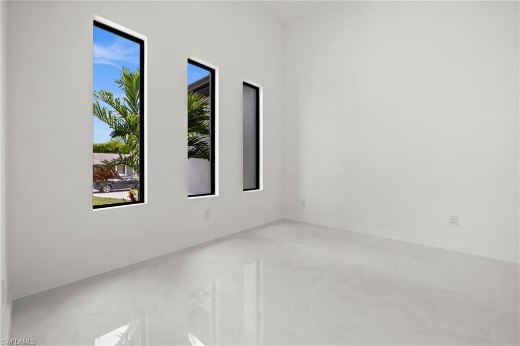 Interior room featuring white walls, high ceilings, and light-toned tile flooring