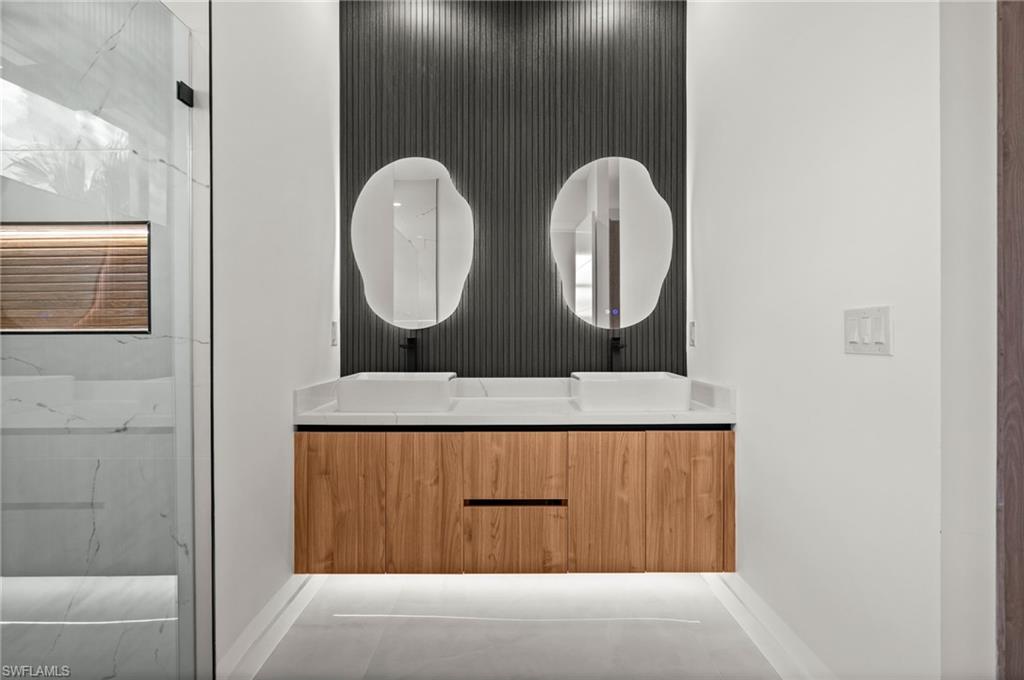 Dual floating vanities featuring wood-finish cabinetry and white vessel sinks