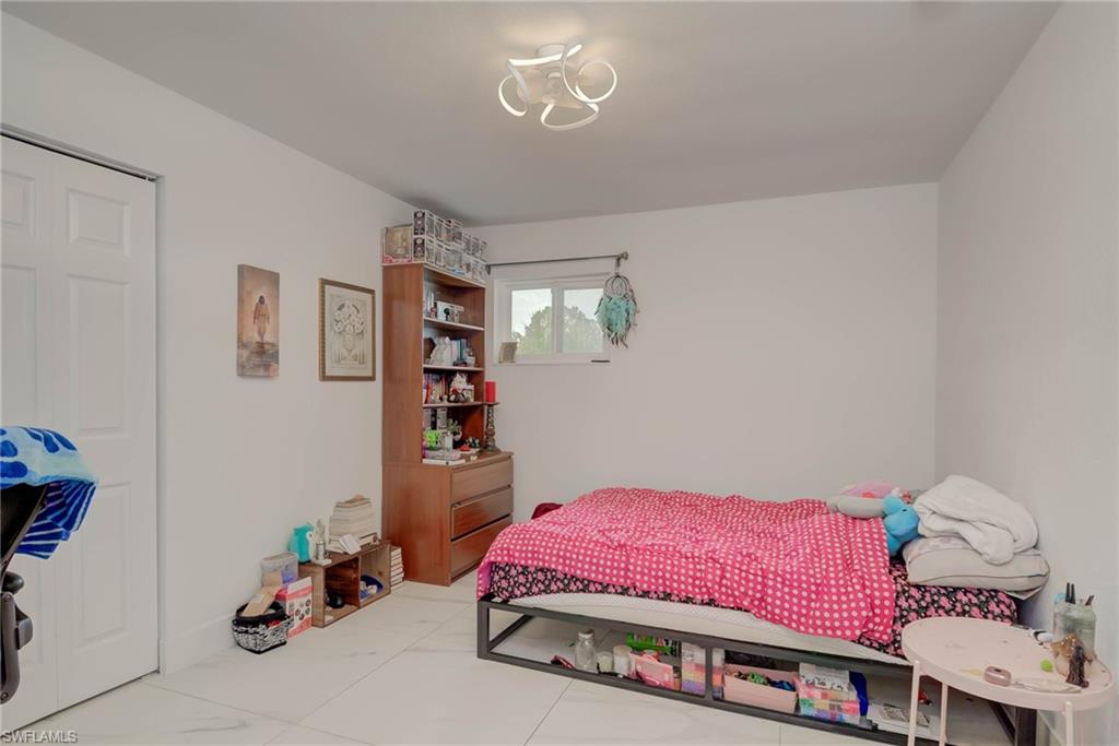 White walls featuring a contemporary ceiling light fixture and a single window