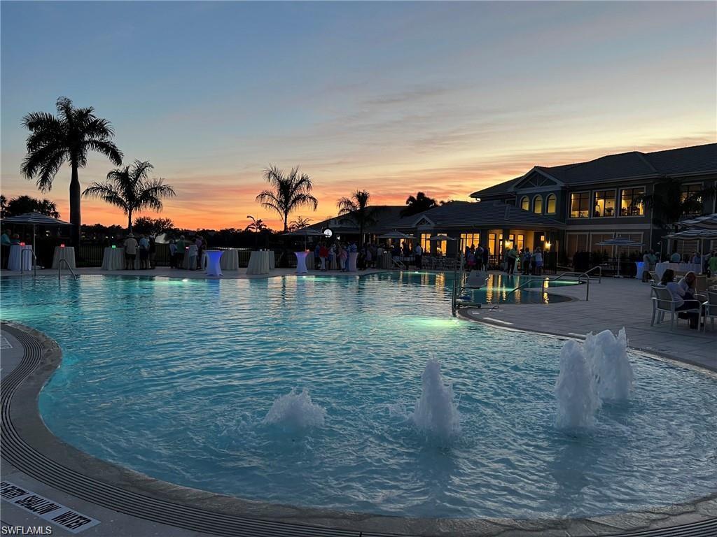 Expansive outdoor pool area featuring fountains, integrated lighting, and multiple seating arrangements