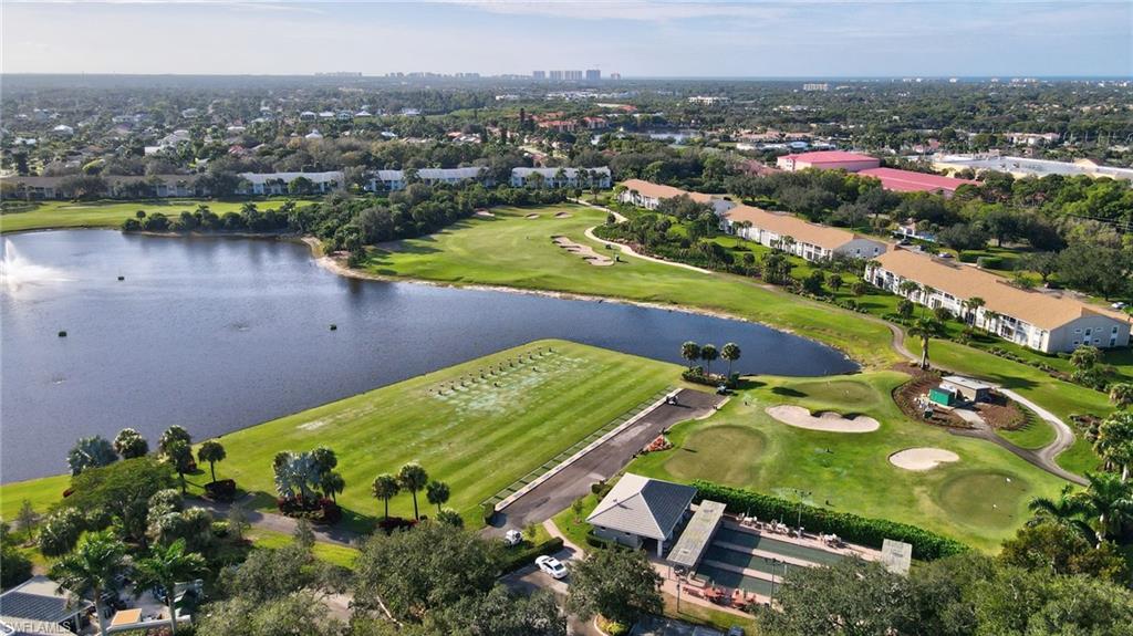 Expansive golf course and lake environment featuring multiple greens, sand traps, and a driving range with a water hazard