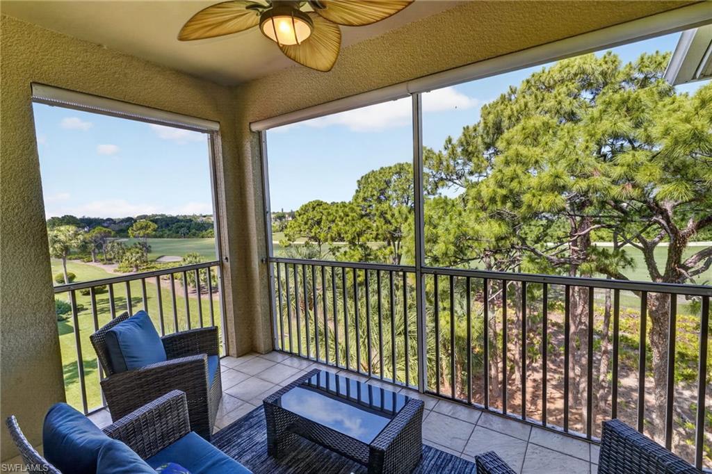 Screened outdoor balcony with a paddle-bladed ceiling fan, tile flooring, and metal railings