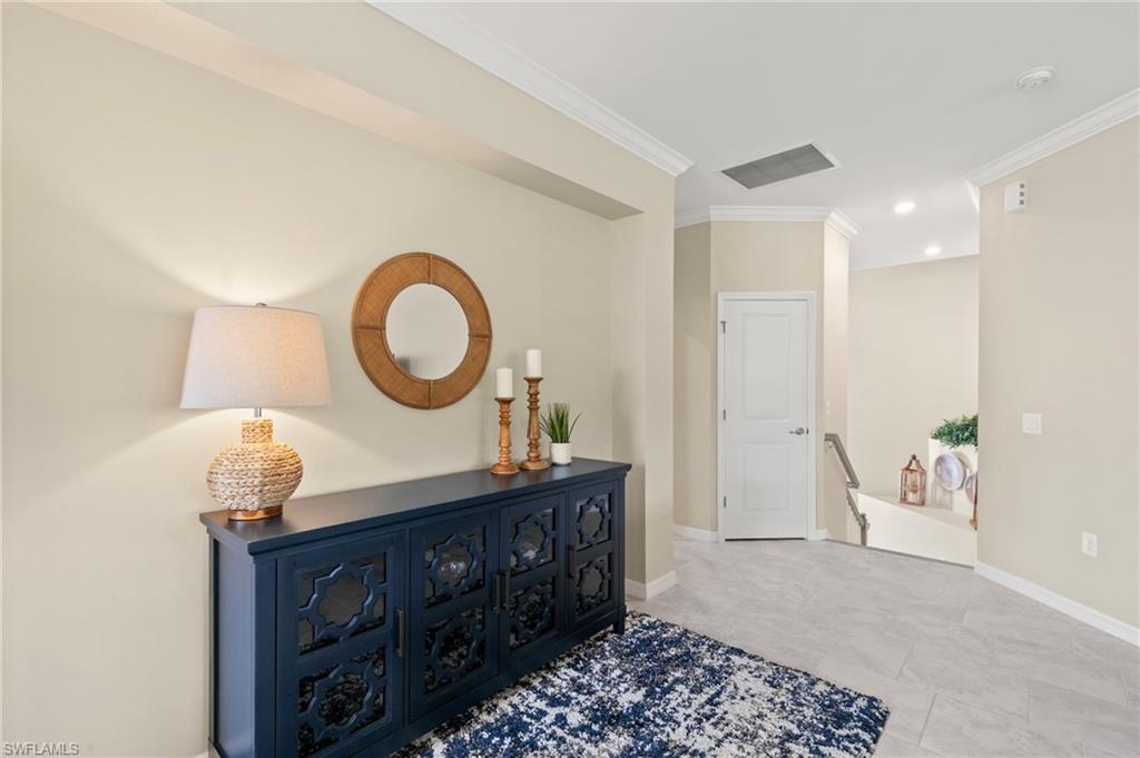 Foyer featuring light-toned walls, crown molding, and recessed lighting