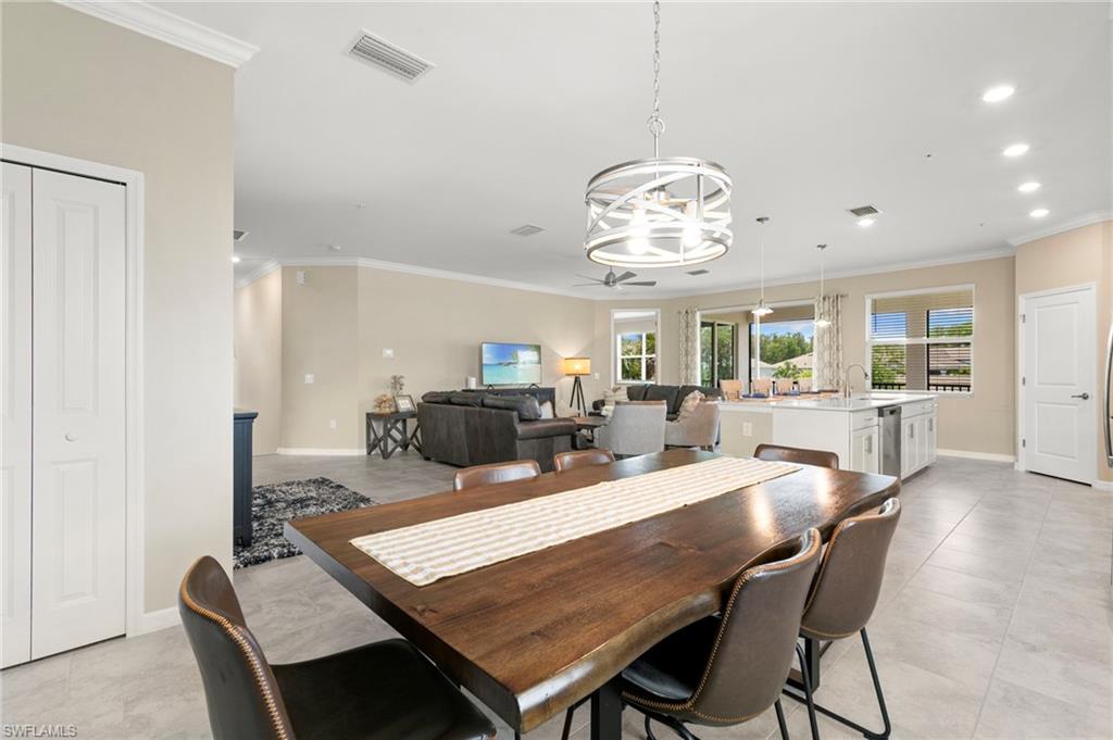 Dining area featuring a contemporary chandelier, wood-finish flooring, and crown molding