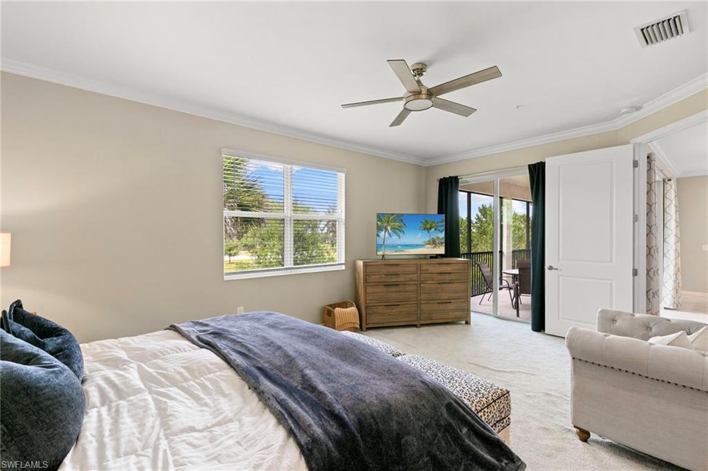 Carpeted interior space featuring a ceiling fan with integrated lighting, crown molding, and a sliding glass door opening to a private balcony