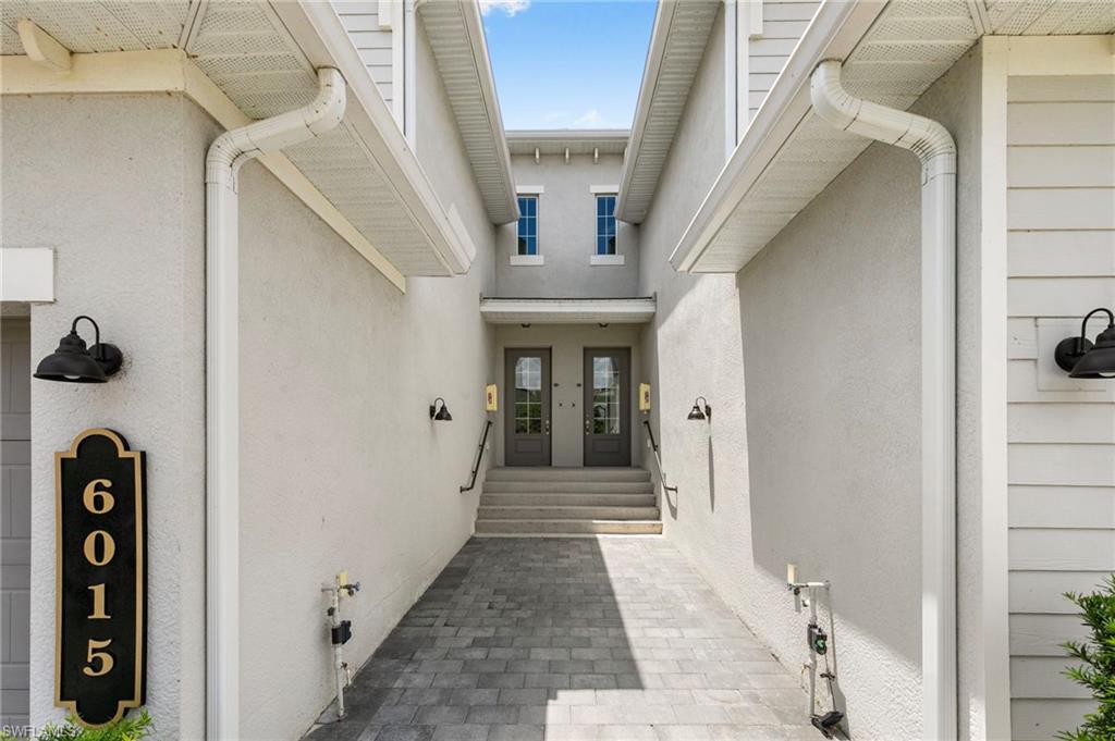 Paved entry corridor leading to a double-door entrance with transom windows above