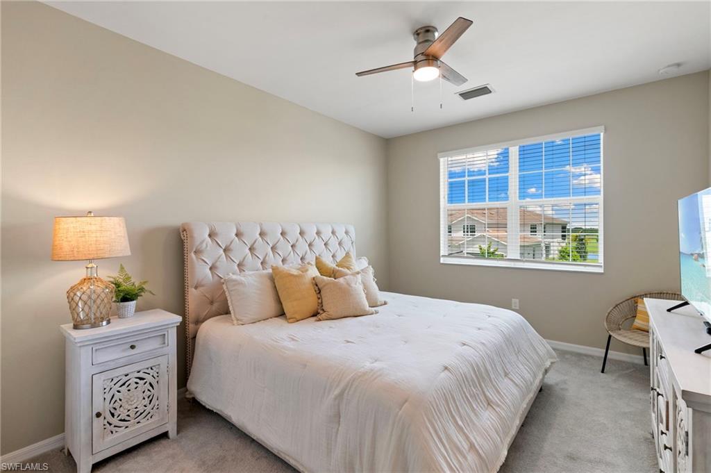 Spacious room featuring a large window, neutral wall tones, and plush carpeting