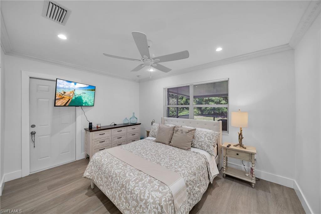 Bright interior space featuring wood-finish flooring, recessed lighting, and crown molding