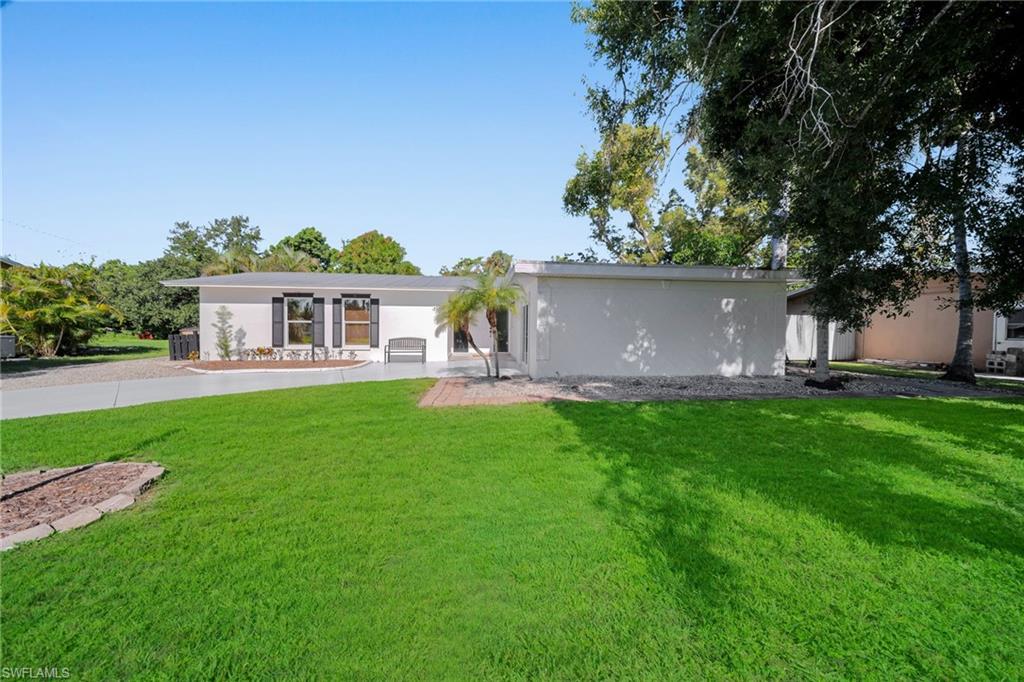 Single-story residence featuring a gray roofline, white exterior, and dark window shutters