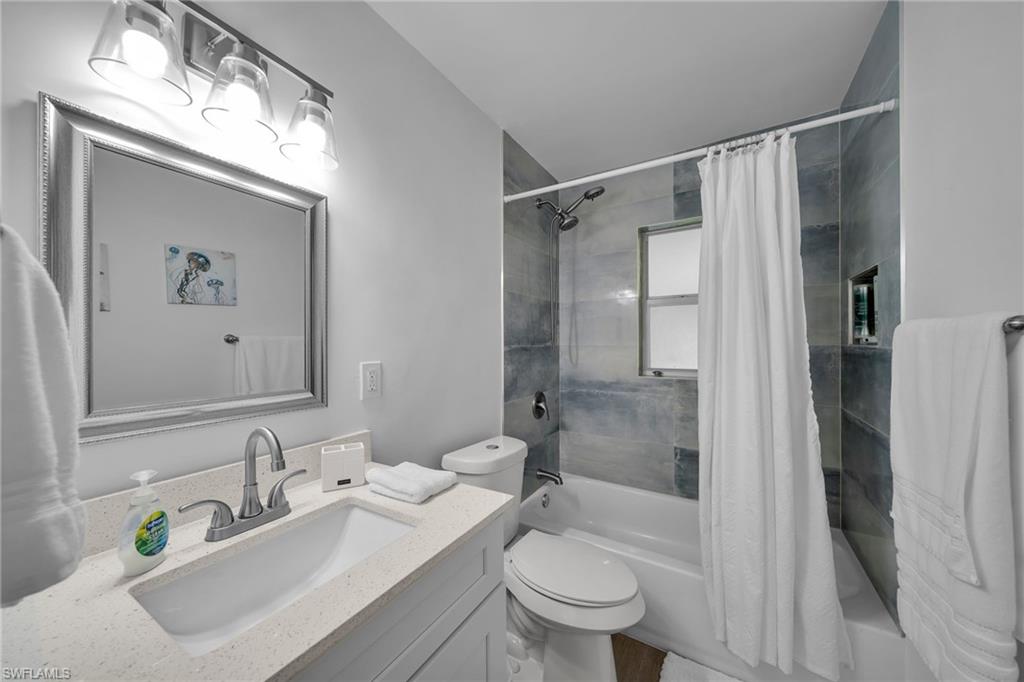 Bathroom featuring a tub/shower combination with tile surround, a built-in shower niche, and a window