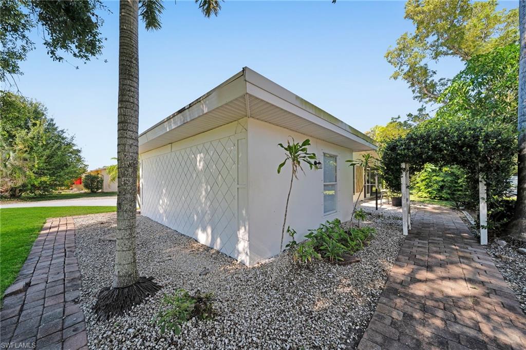 White stucco exterior featuring a decorative lattice panel and a flat roofline