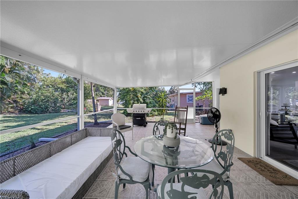 Screened patio featuring a solid roof, large format tile flooring, and a sliding glass door entry to the interior