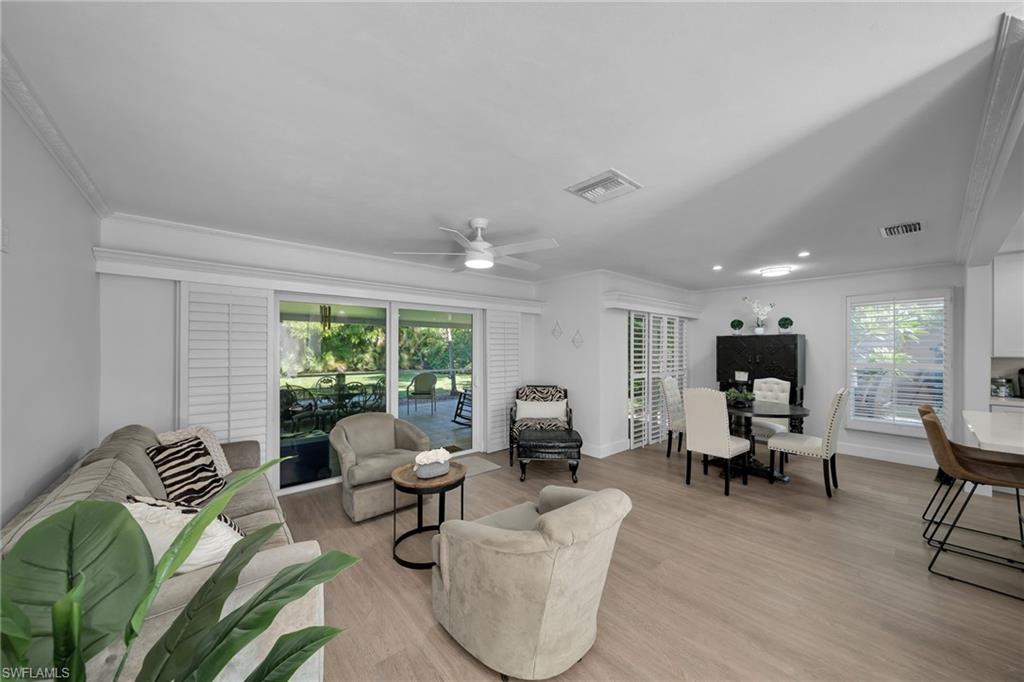 Open-concept interior featuring light wood-finish flooring, white crown molding, and recessed lighting
