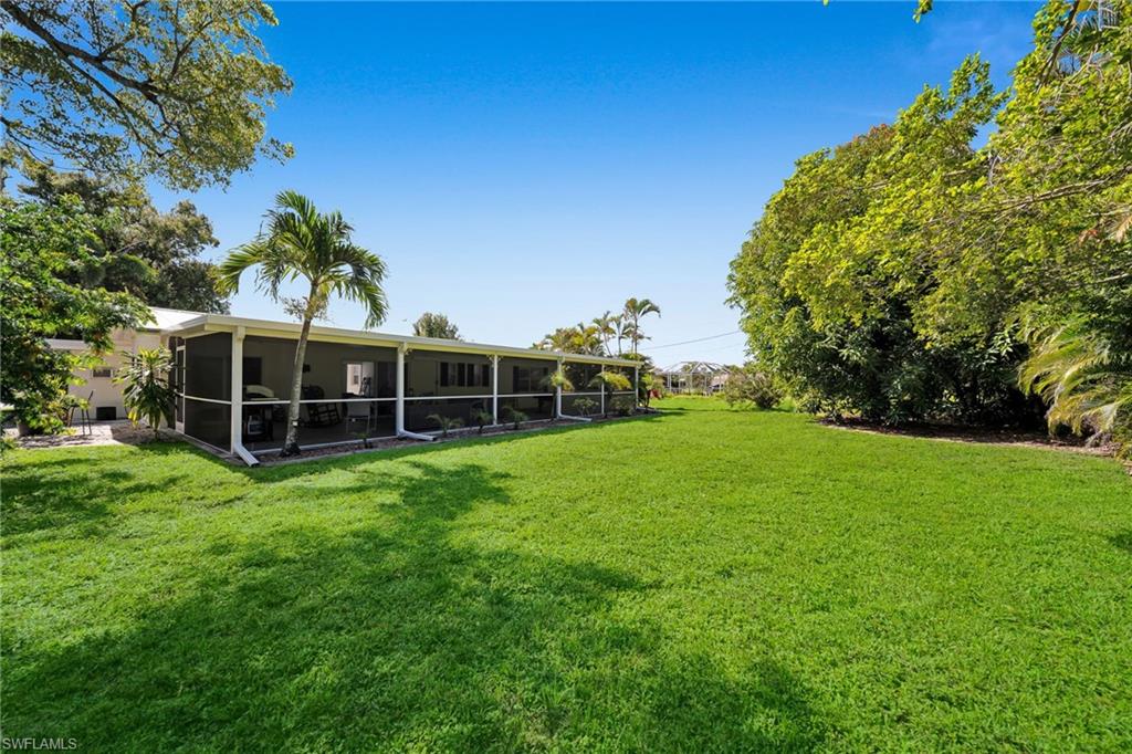 Expansive green lawn with mature trees bordering the property