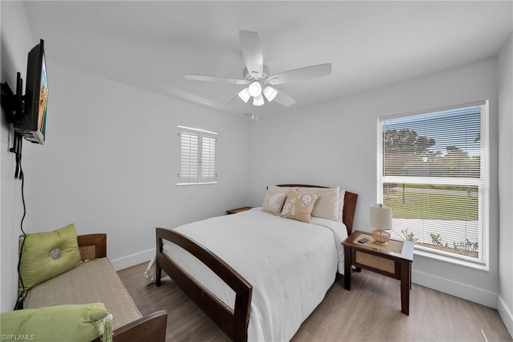 Light-filled room featuring durable wood-finish flooring and a contemporary ceiling fan with integrated lighting