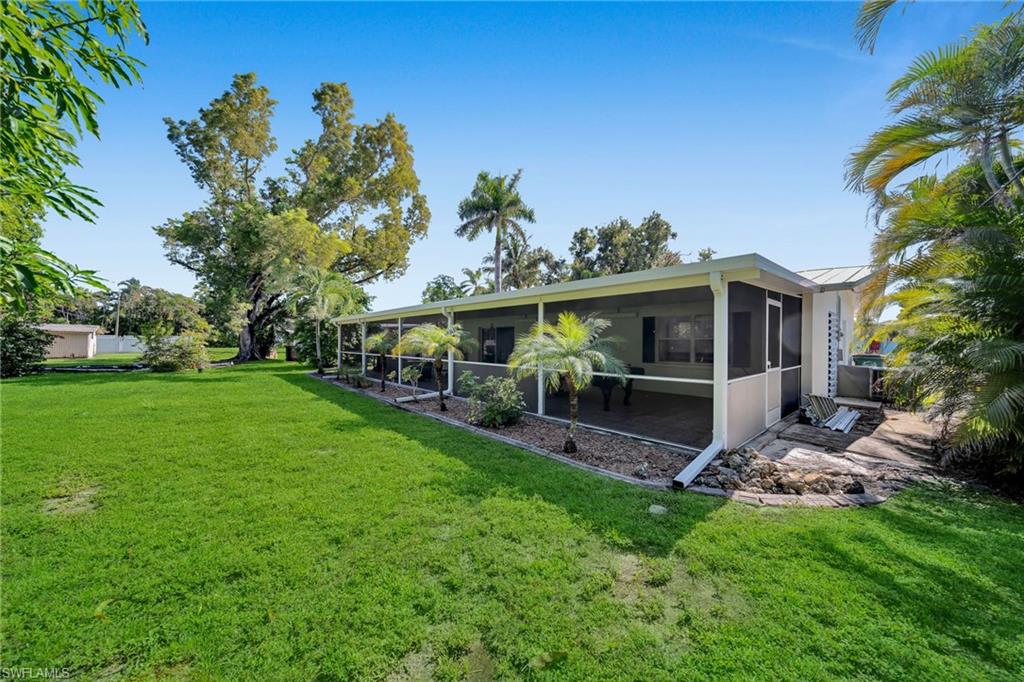 Expansive green lawn with mature trees and tropical landscaping