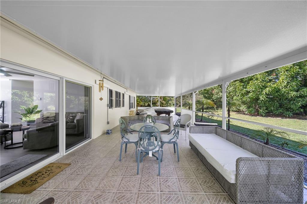 Expansive covered patio featuring a white ceiling and patterned tile flooring