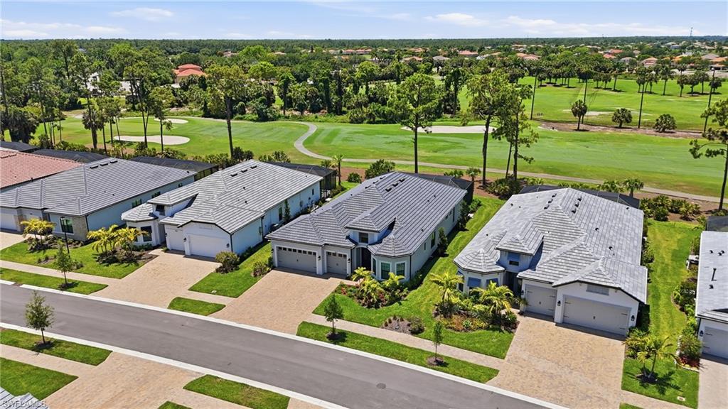 Aerial depiction of a residential street with homes featuring light-colored exteriors and dark tile roofs