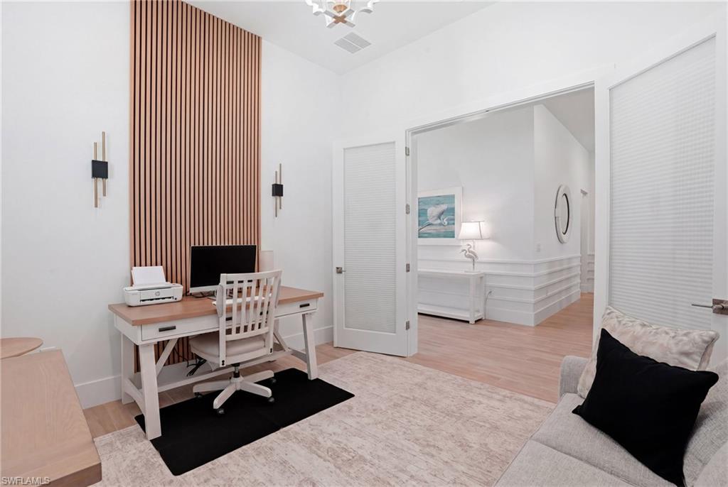 Interior space featuring a vertical wood slat accent wall with integrated sconce lighting