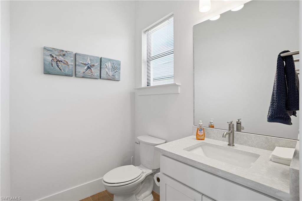 Modern bathroom featuring a single vanity with an integrated sink, a light-toned countertop, and a large wall-mounted mirror