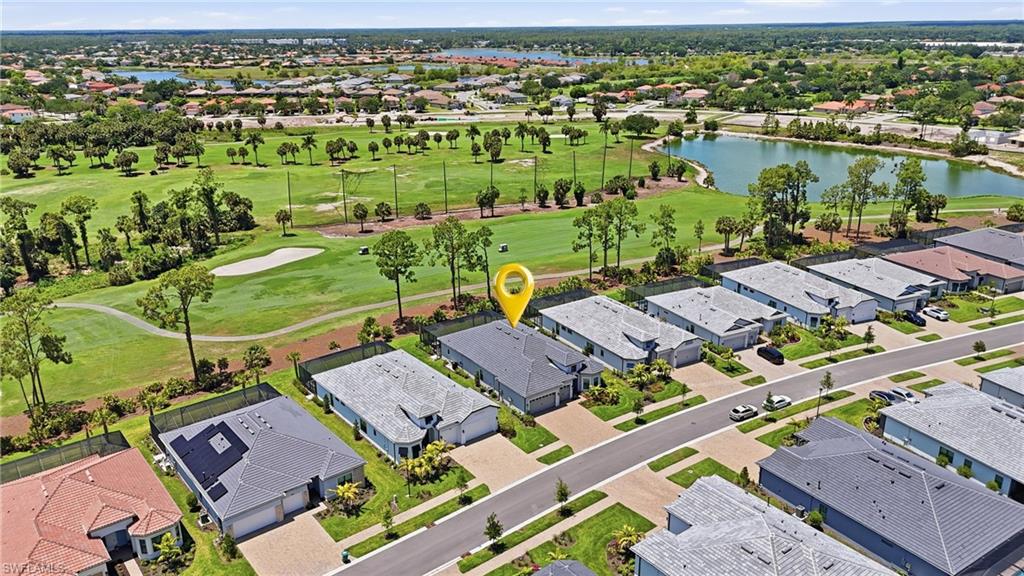 Aerial perspective highlighting a single-story residence with a paved driveway and an attached two-car garage
