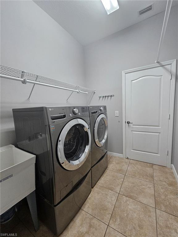 Utility room with light neutral wall paint and tile flooring