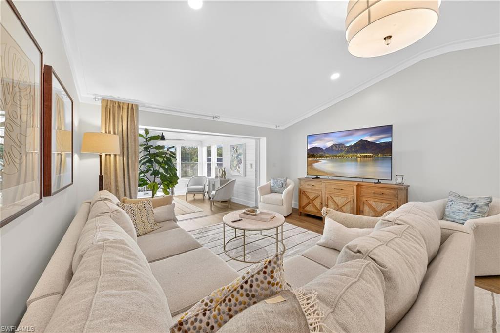 Spacious living area featuring light-toned walls and crown molding