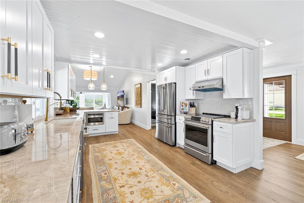 Kitchen featuring white cabinetry, light countertops, and wood-finish flooring
