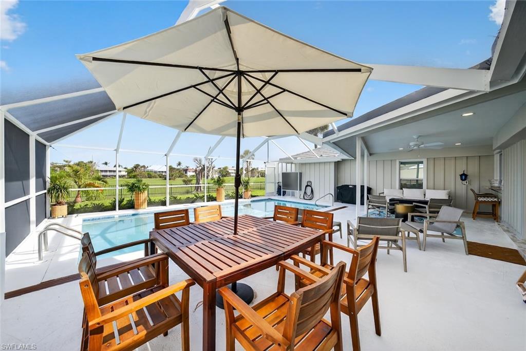 Screened patio area featuring a swimming pool, expansive pool deck, covered outdoor living space, and a ceiling fan
