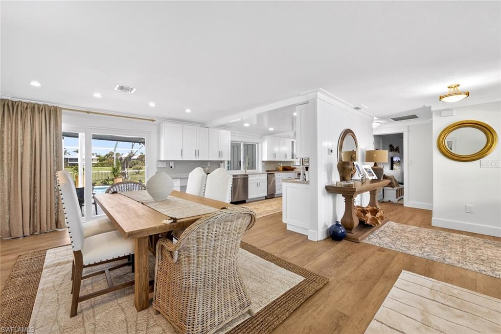 Open-concept interior featuring wood-finish flooring, recessed lighting, and white baseboards