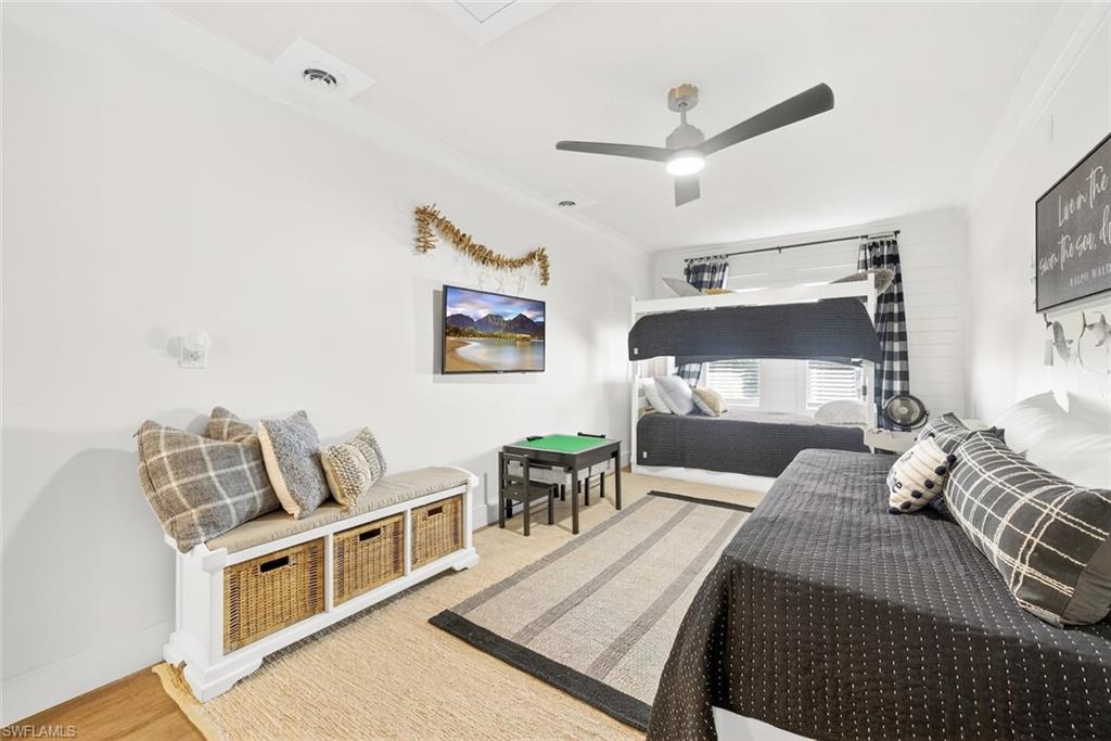 Room featuring a ceiling fan with integrated lighting, wood-finish flooring, and white painted walls