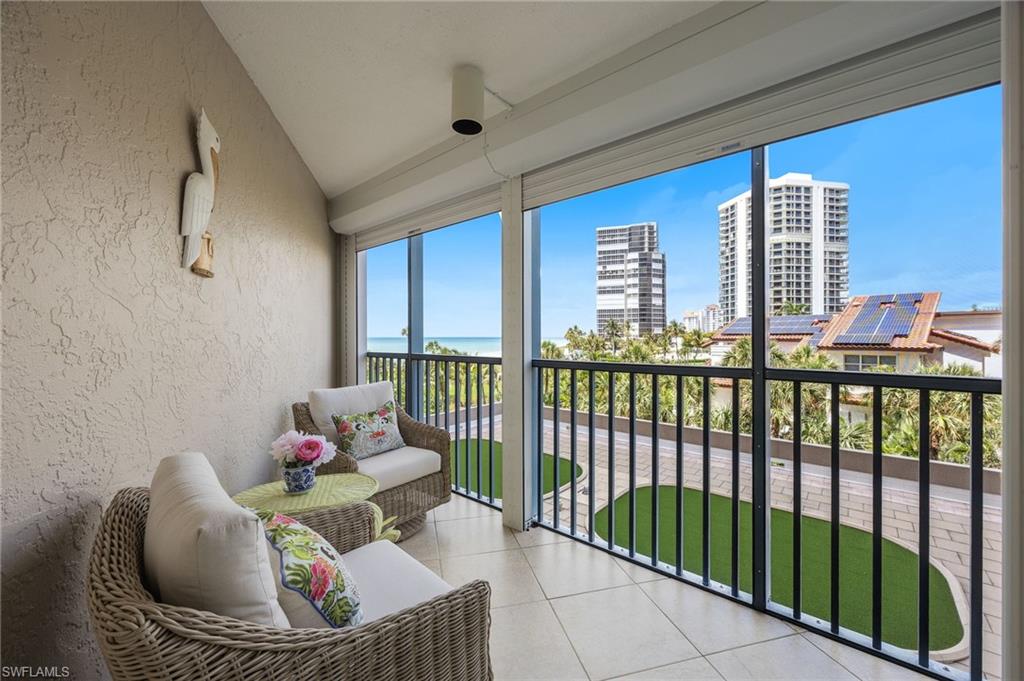 Screened in balcony with a partial coastal view.