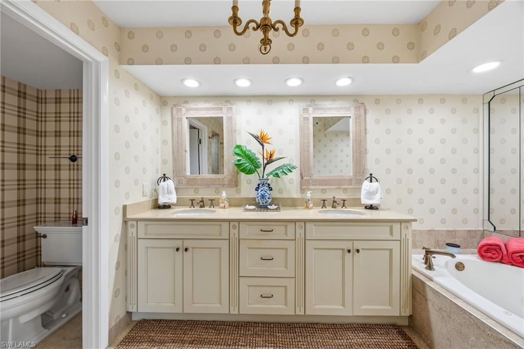 Primary bathroom with dual vanity sinks and tub.