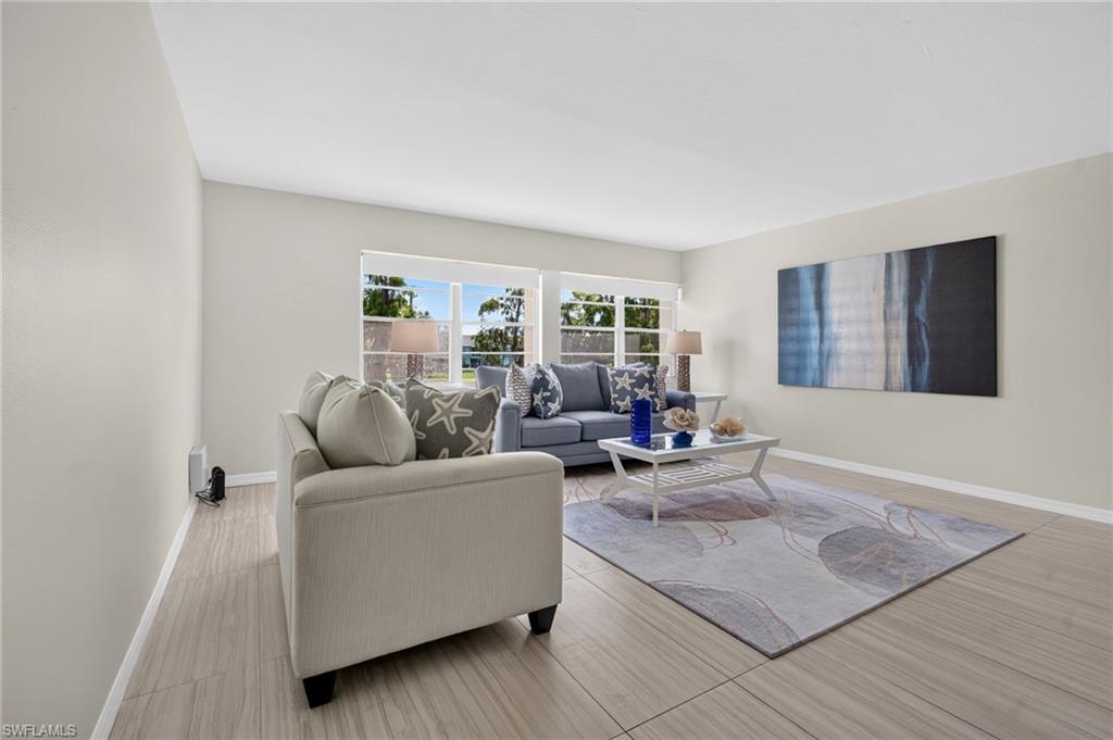 Light-toned plank-style flooring, white walls, and large windows with privacy blinds