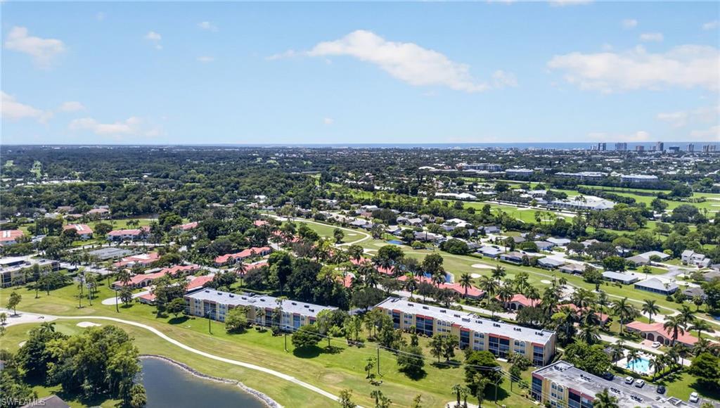 Expansive landscape featuring golf course fairways, mature trees, and a distant cityscape