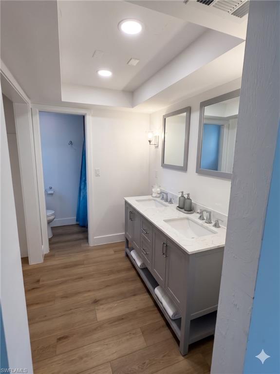 Double vanity with gray cabinetry, white countertops, and dual undermount sinks
