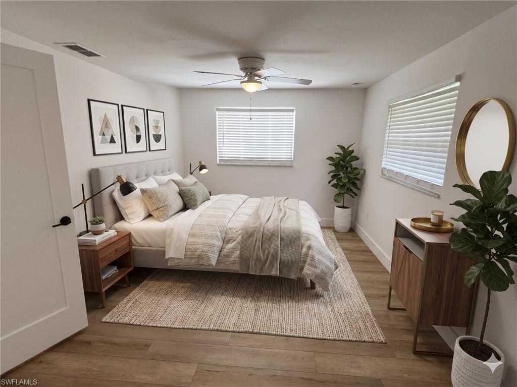 Bright interior space featuring wood-finish flooring, white walls, and a ceiling fan with integrated lighting