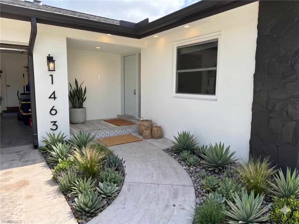 Contemporary exterior featuring a white stucco facade with black stone accents