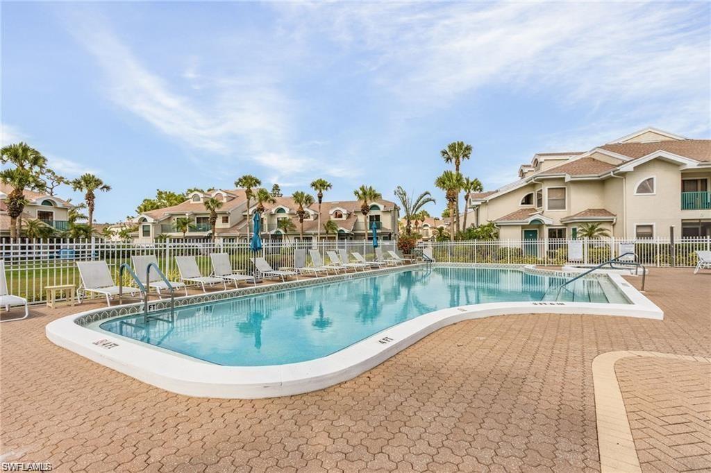 Pool featuring a patio area, a residential view, and fence
