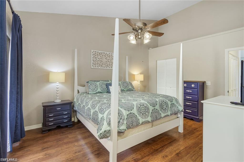 Bedroom featuring dark wood-style flooring, a closet, and ceiling fan