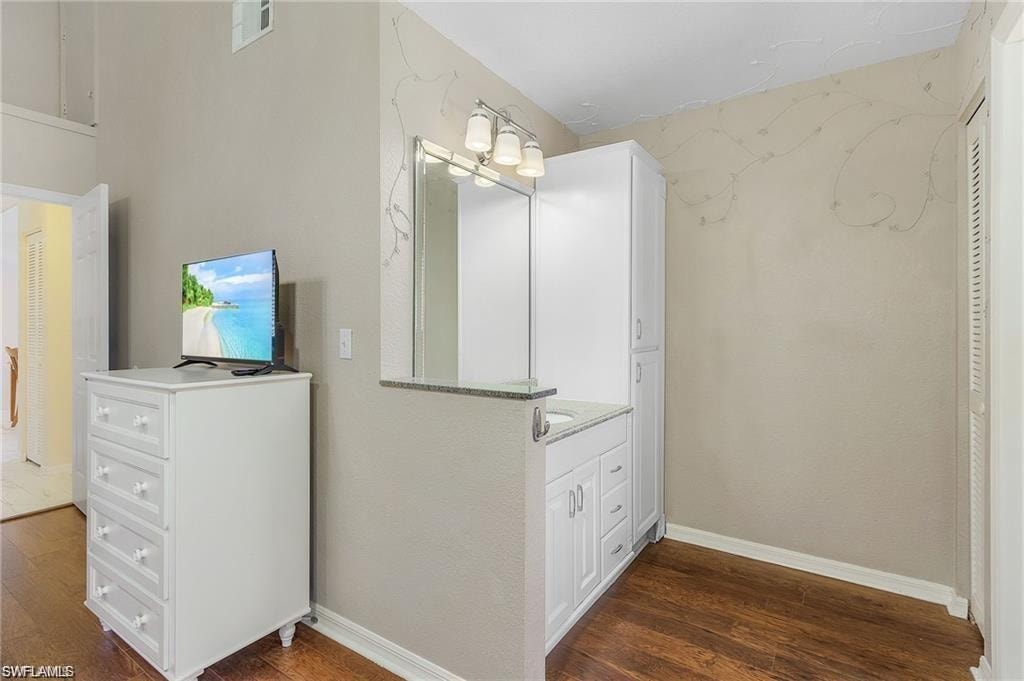 Bathroom with visible vents, baseboards, and wood finished floors