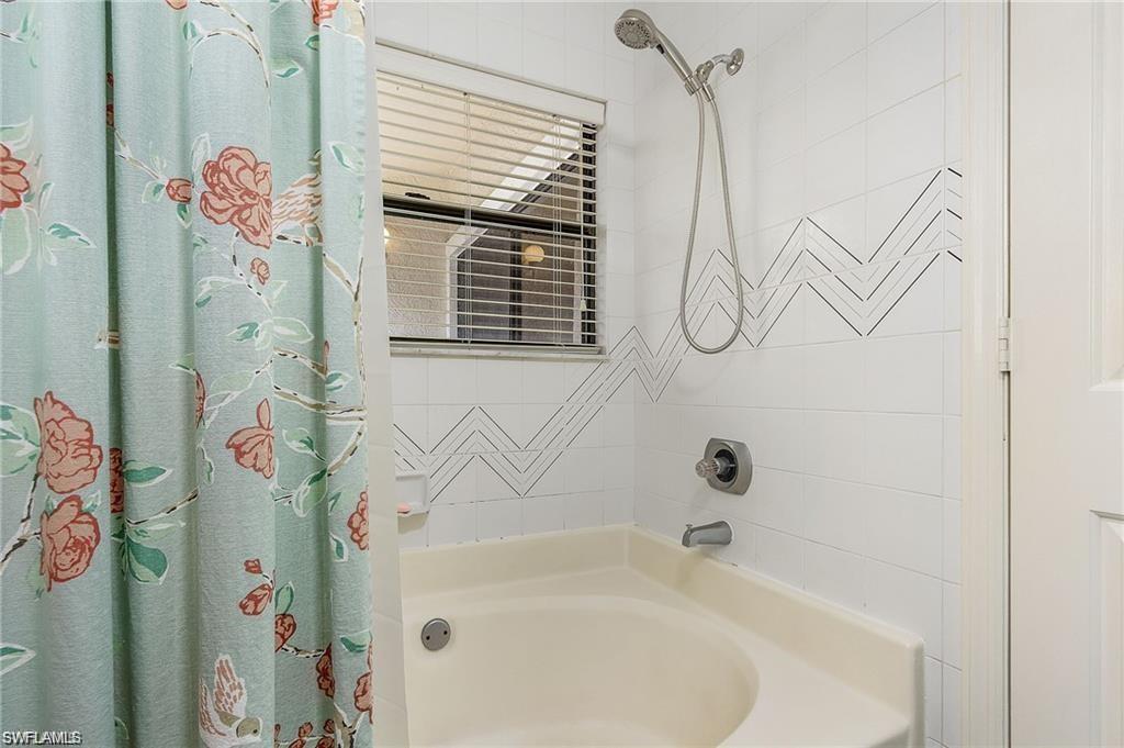 Bathroom with shower / bathtub combination with curtain