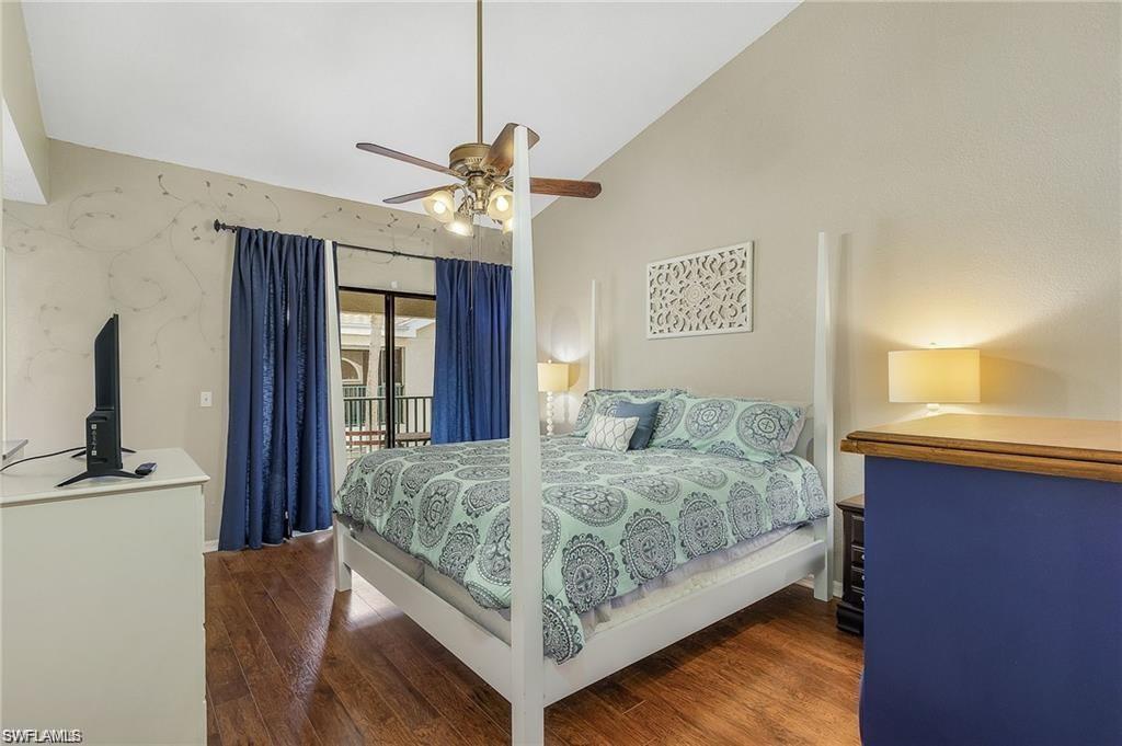 Bedroom with lofted ceiling, wood finished floors, a ceiling fan, and access to outside