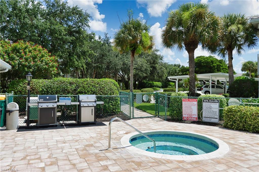 View of pool featuring a patio, a grill, and a hot tub