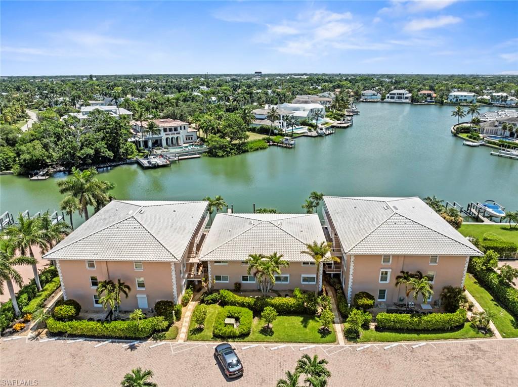 Waterfront residential complex featuring three multi-story buildings with tile roofs and stucco exteriors