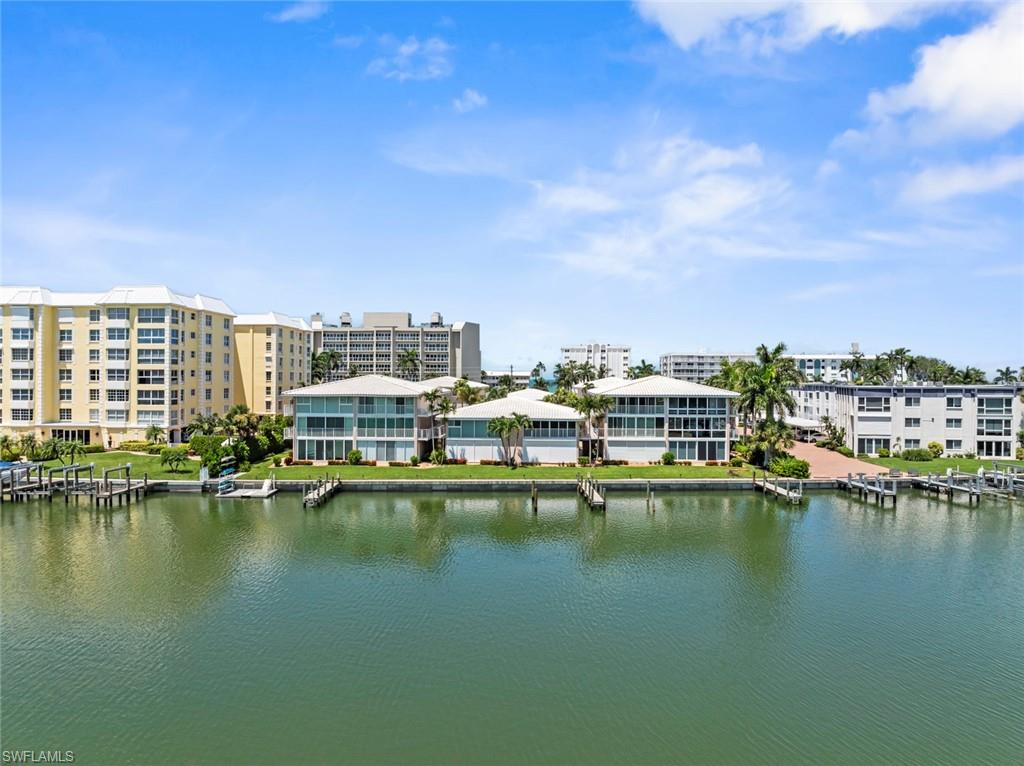 Waterfront property featuring multiple boat docks, manicured green spaces, and a modern architectural design with large windows