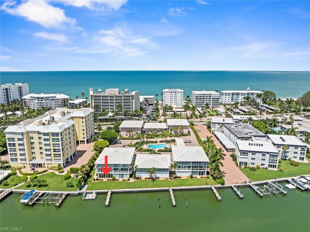 Waterfront property featuring a private boat dock, green lawn space, and a multi-level structure