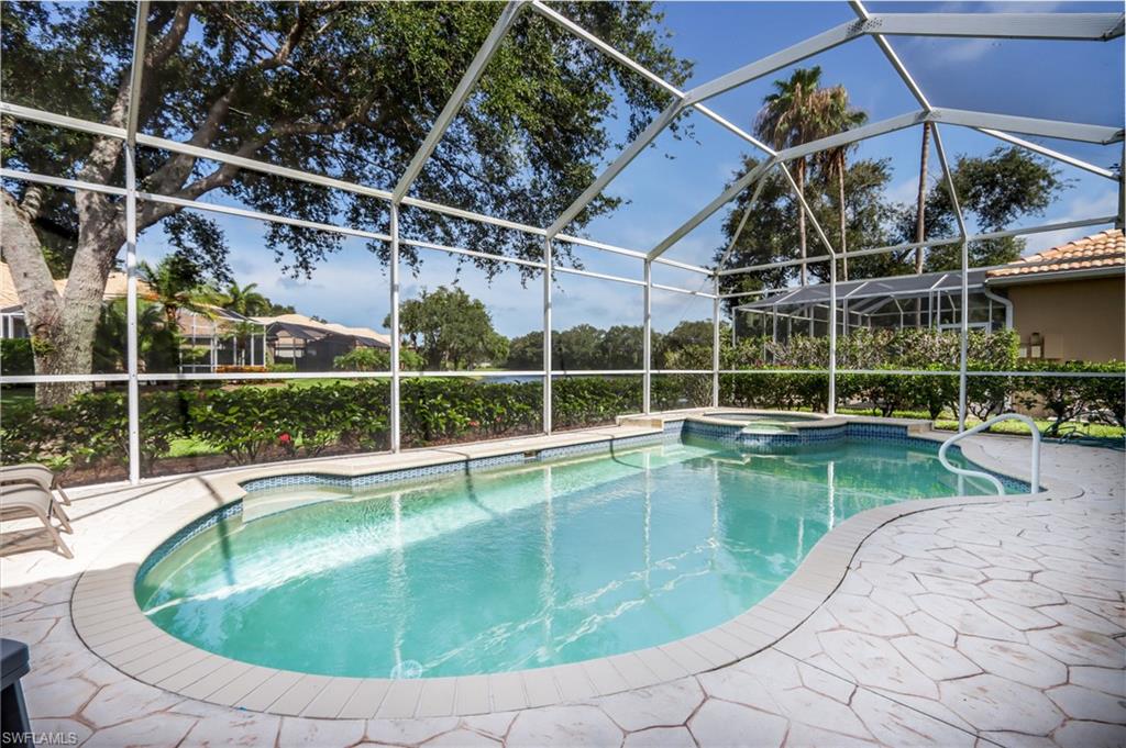 View of pool with a pool with connected hot tub, a lanai, and a patio