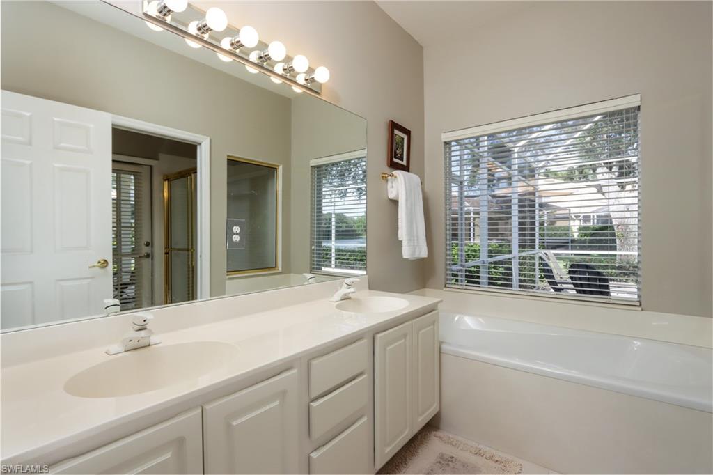 Full bath with a garden tub, double vanity, a shower stall, and tile patterned floors