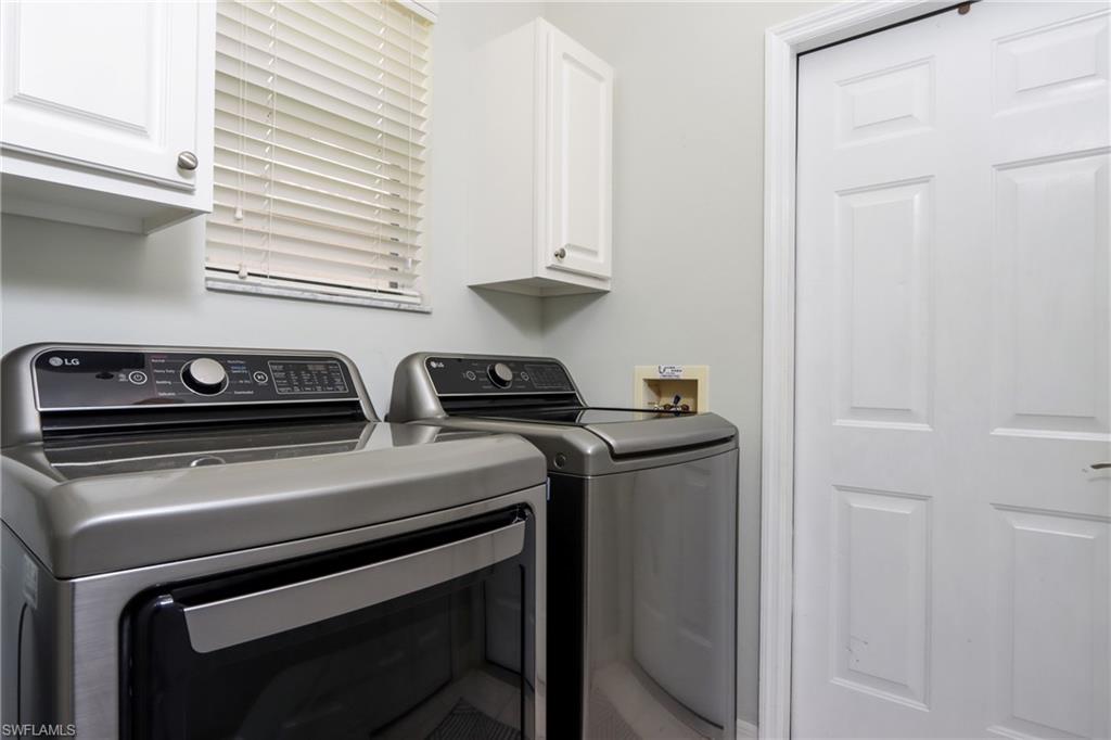 Washroom with washing machine and clothes dryer and cabinet space